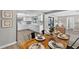 Bright dining room with wood table, seating for six, and an open view to the renovated kitchen at 6310 Gainsboro Ave, Spring Hill, FL 34609