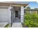 View of front entrance through decorative gate showing covered porch at 6310 Gainsboro Ave, Spring Hill, FL 34609