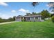 Charming home features a manicured lawn, gray exterior, and attached garage at 6310 Gainsboro Ave, Spring Hill, FL 34609