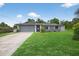 Charming one-story home featuring a well-manicured lawn and a gray painted exterior at 6310 Gainsboro Ave, Spring Hill, FL 34609
