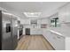Bright kitchen featuring stainless steel appliances, white cabinets, and wood flooring at 6310 Gainsboro Ave, Spring Hill, FL 34609