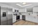 Modern kitchen with white cabinets, stainless steel appliances, and wood flooring at 6310 Gainsboro Ave, Spring Hill, FL 34609