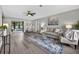 Open-concept living room with gray walls, ceiling fan, wood flooring, and neutral furnishings at 6310 Gainsboro Ave, Spring Hill, FL 34609