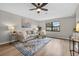 Bright living room featuring a ceiling fan, large window, and neutral decor at 6310 Gainsboro Ave, Spring Hill, FL 34609