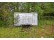 Metal storage shed with closed doors located in grassy area near trees at 6310 Gainsboro Ave, Spring Hill, FL 34609