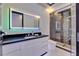 Beautiful bathroom features a modern vanity, illuminated mirror, and a walk-in shower at 6530 Simone Shores Cir, Apollo Beach, FL 33572