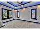 A modern bedroom features three windows with natural light and unique blue lighting accents at 6530 Simone Shores Cir, Apollo Beach, FL 33572