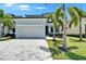 Charming single-Gathering home featuring a two-car garage, lush landscaping, and beautiful palm trees at 6530 Simone Shores Cir, Apollo Beach, FL 33572