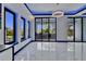 Bright living room with a chandelier, large windows and glass doors that open to an outdoor kitchen area at 6530 Simone Shores Cir, Apollo Beach, FL 33572