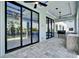 A covered patio features multiple glass sliding doors and an outdoor kitchen with a gas grill at 6530 Simone Shores Cir, Apollo Beach, FL 33572