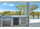 A covered patio features an outdoor kitchen with a sink, beverage cooler, and views of the yard at 6530 Simone Shores Cir, Apollo Beach, FL 33572