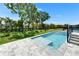 Sparkling pool with step entry and stone patio complements the lush landscaped backyard at 6530 Simone Shores Cir, Apollo Beach, FL 33572