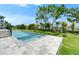 Resort-style backyard with pool, spa, stone patio, lush lawn, and private landscaping at 6530 Simone Shores Cir, Apollo Beach, FL 33572