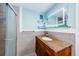Bright bathroom featuring granite vanity, large mirror and shower with light blue walls and light grey trim at 6618 N 11Th St, Tampa, FL 33604