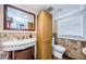 Well-lit bathroom featuring a sink, toilet and storage cabinet with decorative backsplash and floors at 6618 N 11Th St, Tampa, FL 33604