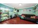 Inviting bedroom furnished with a futon, plants, weights and equipment, and stylish decor with hardwood floors at 6618 N 11Th St, Tampa, FL 33604