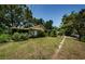 Exterior of the property featuring mature landscaping, a green lawn, and a sidewalk at 6618 N 11Th St, Tampa, FL 33604