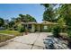 Exterior view of the home featuring mature landscaping and an extended driveway at 6618 N 11Th St, Tampa, FL 33604