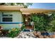 Cozy entrance with a covered porch adorned with plants, stone accents, and blue trim at 6618 N 11Th St, Tampa, FL 33604