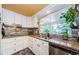 Well-lit kitchen features granite countertops, white cabinets, and a garden window at 6618 N 11Th St, Tampa, FL 33604