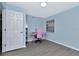 Bedroom with blue walls, desk area, and a bright window view at 6817 Stones Throw N Cir # 17203, St Petersburg, FL 33710