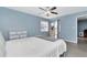 This bedroom features blue walls, a ceiling fan, and a sliding door to a balcony at 6817 Stones Throw N Cir # 17203, St Petersburg, FL 33710