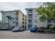 Condominium exterior with balconies, lush tree and parking spots at 6817 Stones Throw N Cir # 17203, St Petersburg, FL 33710