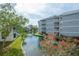 Beautiful waterfront condo building with private balconies, lush landscaping, and serene canal views at 6817 Stones Throw N Cir # 17203, St Petersburg, FL 33710