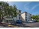 Exterior view showing building facade, parking area, and surrounding shade trees at 6817 Stones Throw N Cir # 17203, St Petersburg, FL 33710