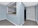 Cozy living room with light blue walls and gray floors leading to the front door and kitchen at 6817 Stones Throw N Cir # 17203, St Petersburg, FL 33710