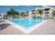 Large community swimming pool with lounge seating, palm trees, and nearby condo buildings under a bright blue sky at 6817 Stones Throw N Cir # 17203, St Petersburg, FL 33710