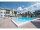Large community pool with lounge chairs, tables, and umbrellas, perfect for relaxing and enjoying the Florida sun at 6817 Stones Throw N Cir # 17203, St Petersburg, FL 33710