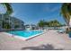 Community pool with brick surround, lounge chairs, and tables under clear blue skies at 6817 Stones Throw N Cir # 17203, St Petersburg, FL 33710