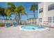 Relaxing spa area with a sparkling hot tub, surrounded by palm trees and a white picket fence at 6817 Stones Throw N Cir # 17203, St Petersburg, FL 33710