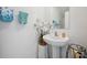 Cozy powder room with pedestal sink, decorative accents, and a neutral color palette at 71 Rose Bud Ln, Spring Hill, FL 34609