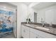 Bright bathroom featuring double vanity with granite countertop and decorative hummingbird shower curtain at 71 Rose Bud Ln, Spring Hill, FL 34609