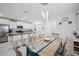Inviting dining area with a decorative chandelier and a view into the modern, open-concept kitchen at 71 Rose Bud Ln, Spring Hill, FL 34609
