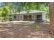 Backyard featuring mature trees, a screened porch, and a small deck with natural landscaping at 7644 Conrad St, Wesley Chapel, FL 33544