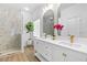 Bathroom featuring a marble walk-in shower and a vanity with double sinks and framed mirrors at 7644 Conrad St, Wesley Chapel, FL 33544