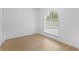 Empty bedroom with a large arched window providing natural light and featuring wood look flooring at 7644 Conrad St, Wesley Chapel, FL 33544