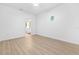 Bright bedroom featuring wood-look flooring, neutral walls, and a unique porthole window at 7644 Conrad St, Wesley Chapel, FL 33544