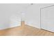 Empty bedroom with wood look flooring, a door to another room and a closet with bi-fold doors at 7644 Conrad St, Wesley Chapel, FL 33544