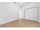 Empty bedroom featuring wood look floors and closet with double bi-fold doors at 7644 Conrad St, Wesley Chapel, FL 33544