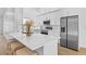 Kitchen with modern stainless steel appliances, marble countertops, white cabinets and seating at the kitchen island at 7644 Conrad St, Wesley Chapel, FL 33544
