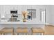Bright kitchen featuring white cabinets, modern stainless steel appliances, and a marble countertop island with seating at 7644 Conrad St, Wesley Chapel, FL 33544