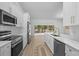 Bright kitchen with modern stainless steel appliances, subway tile backsplash, white cabinets and island seating at 7644 Conrad St, Wesley Chapel, FL 33544