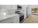 Bright kitchen with modern stainless steel appliances, tile backsplash, white cabinets and breakfast nook at 7644 Conrad St, Wesley Chapel, FL 33544