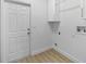 Functional laundry room showcasing storage cabinets, washer/dryer hookups, and vinyl flooring at 7644 Conrad St, Wesley Chapel, FL 33544