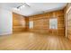 Large, open living room featuring wood walls, plenty of natural light, and wood-look flooring at 7644 Conrad St, Wesley Chapel, FL 33544