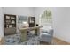 Bright home office with large arched window, stylish decor, a desk and comfortable seating area at 7644 Conrad St, Wesley Chapel, FL 33544